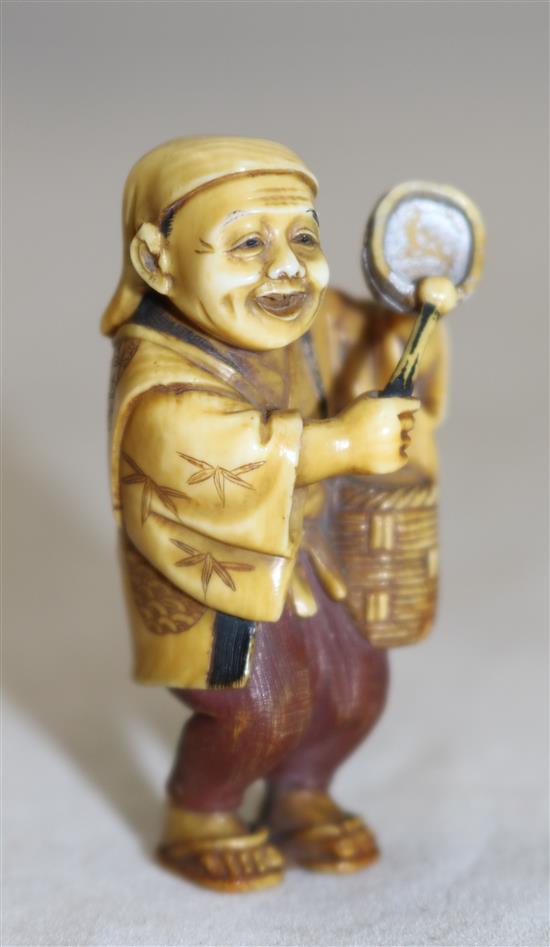 A Japanese tinted ivory figure of a street vendor, Taisho period, 5cm